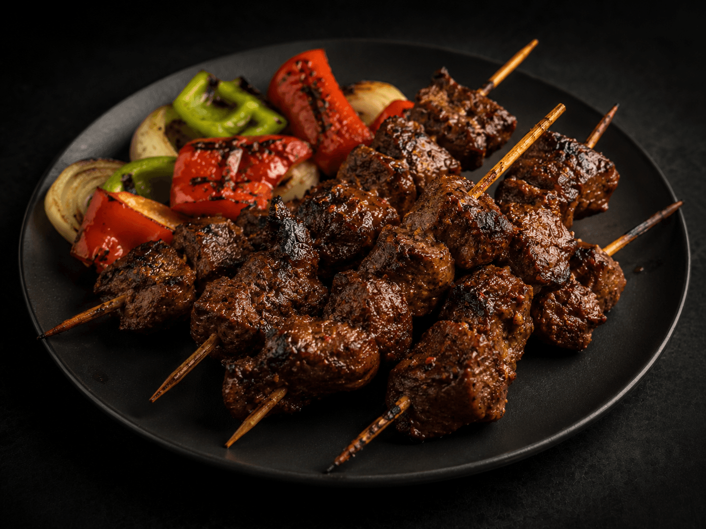Kamundele — bold Congolese beef skewers with charred peppers on a dark slate plate